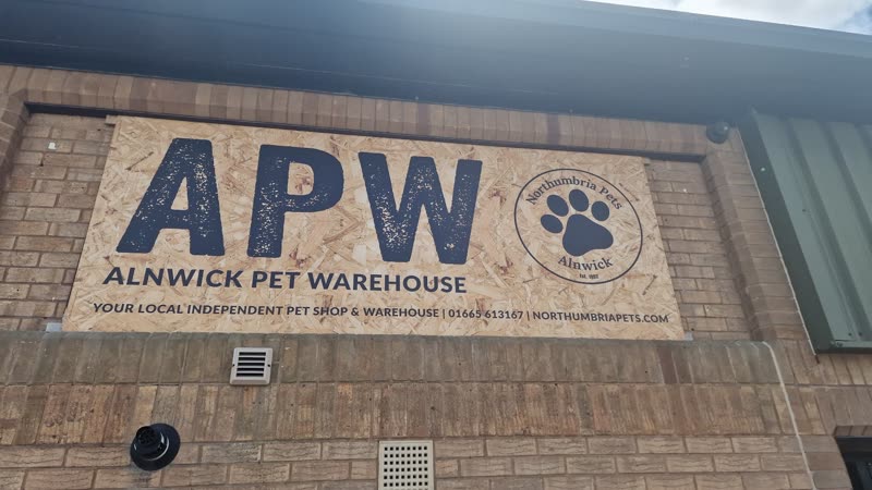 The painted APW paw-logo sign on the brick exterior of the unit at Greensfield Business Park